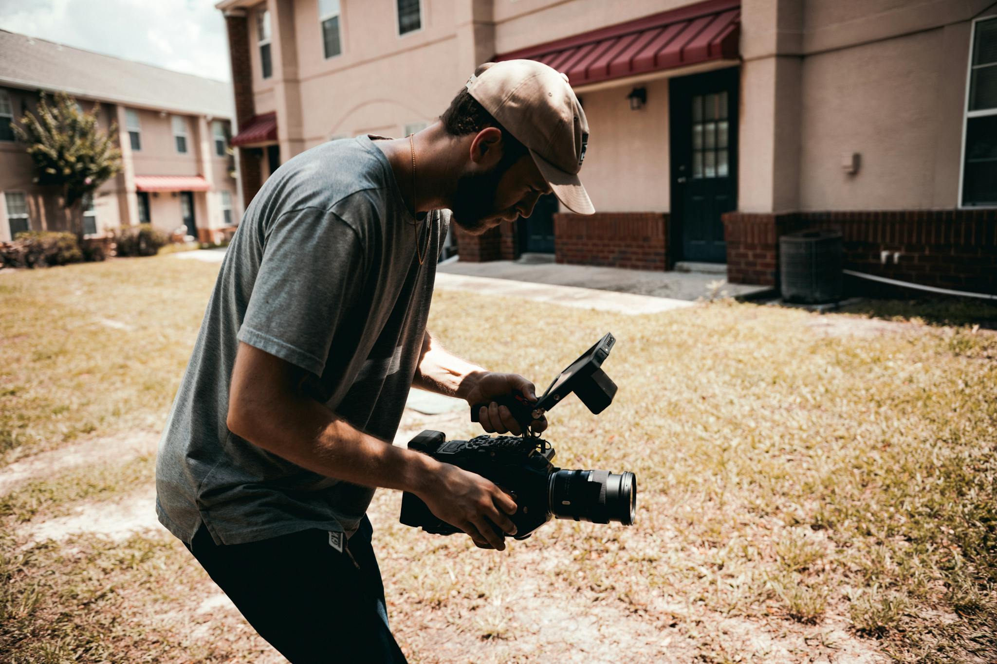 A filmmaker using professional camera gear during an outdoor video shoot.